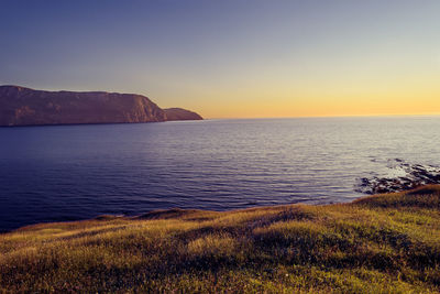 Scenic view of sea against clear sky during sunset