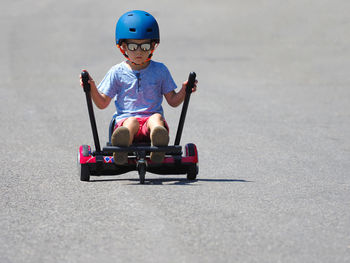 Full length of boy riding segway on road