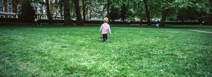 Rear view of man walking on field