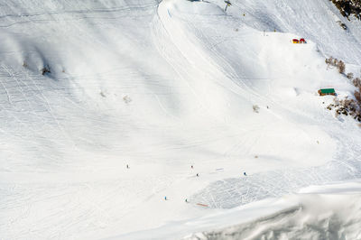 High angle view of people skiing on snow covered land