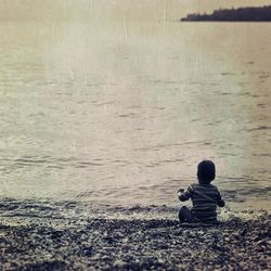 Rear view of woman standing on shore