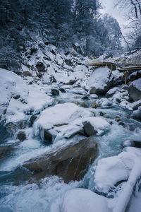 Frozen river amidst snowcapped land