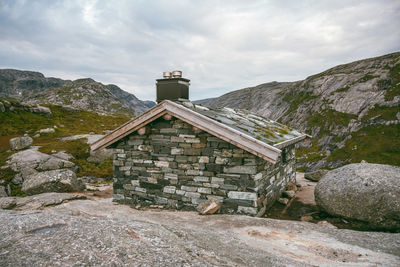 Traditional building by mountains against sky