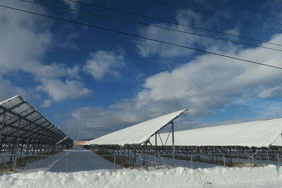 Low angle view of snow covered bridge against sky