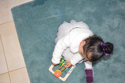 High angle view of boy playing with toy on floor