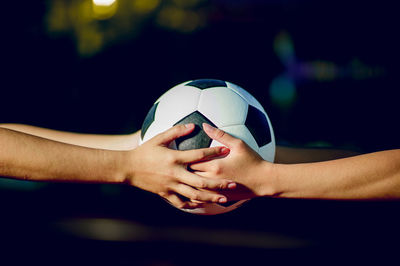 Cropped hands of women holding soccer ball