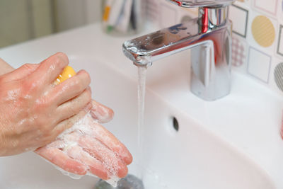 Close-up of human hand in bathroom