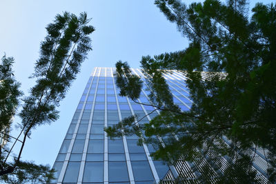 Low angle view of glass building against sky