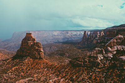 Panoramic view of rock formations on landscape against cloudy sky