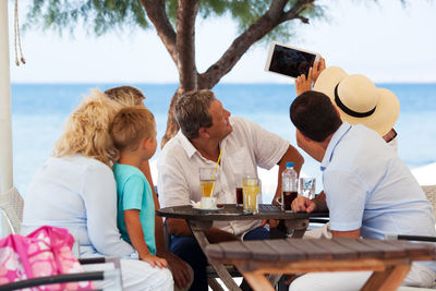 Family taking selfie on table at beach
