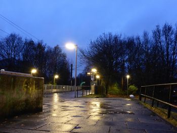 Illuminated road against sky at night