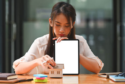 Portrait of woman holding smart phone on table