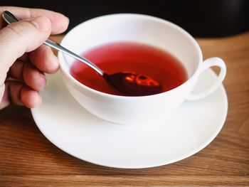 Cropped image of person with tea cup on table