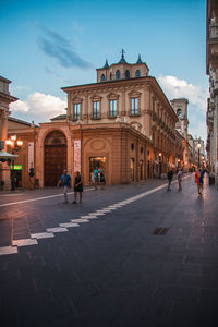 People walking on street amidst buildings in town