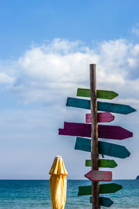 Deck chairs on beach against sky