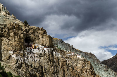 Panoramic view of rock and buildings against sky