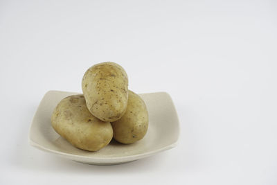 Close-up of cookies in plate against white background