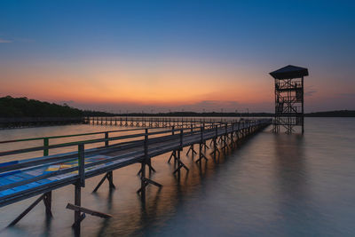 Pier over sea against sky during sunset