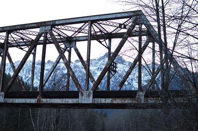 Low angle view of bridge over river against sky