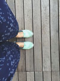 Low section of woman standing on wooden pier