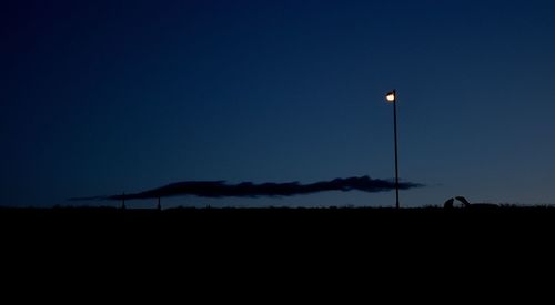 Silhouette landscape against clear sky at night