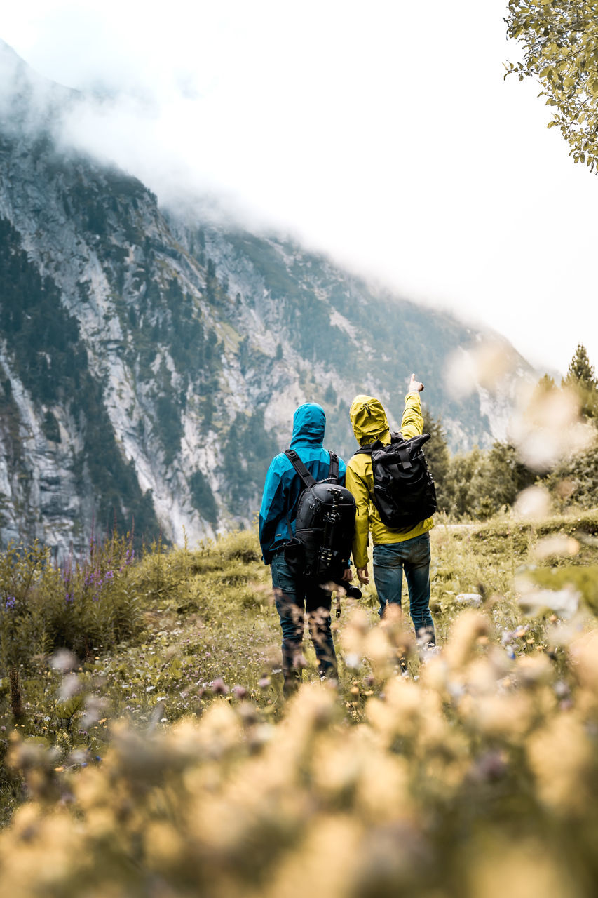 rear view, mountain, nature, plant, leisure activity, selective focus, day, activity, real people, adventure, beauty in nature, hiking, group of people, adult, people, scenics - nature, women, helmet, outdoors, backpack