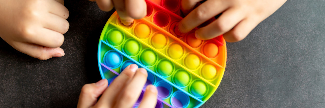 MIDSECTION OF WOMAN HOLDING COLORFUL TOYS