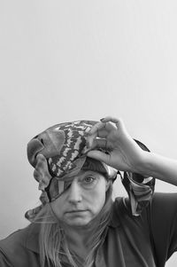 Portrait of woman in headwear against white background