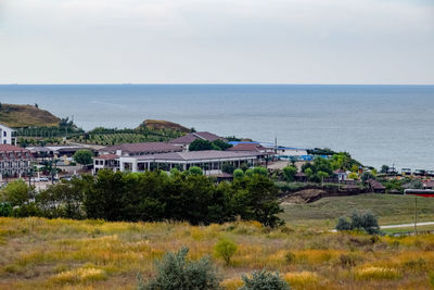 High angle view of houses by sea against sky