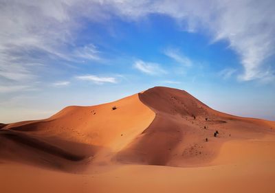 Sand dunes in desert against sky