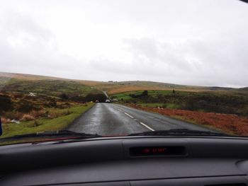 Road passing through landscape seen through car windshield