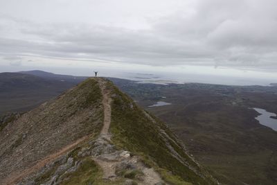 Scenic view of mountain and landscape against cloudy sky