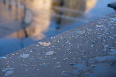 Close-up of water drops on railing