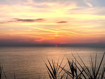 Scenic view of sea against romantic sky at sunset