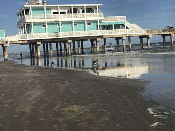 Pier on beach against sky