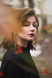 Portrait of beautiful woman with red flower