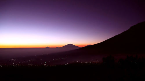 Scenic view of silhouette mountains against sky at sunset