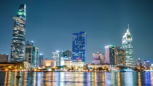 Illuminated buildings against sky at night