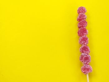 Close-up of multi colored candies against yellow background