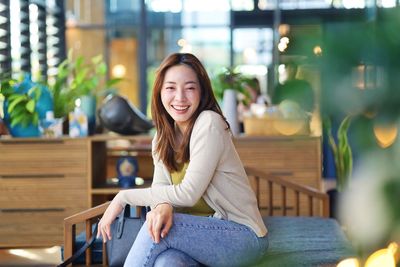 Portrait of young woman sitting on chair