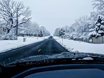 Road seen through car windshield during winter