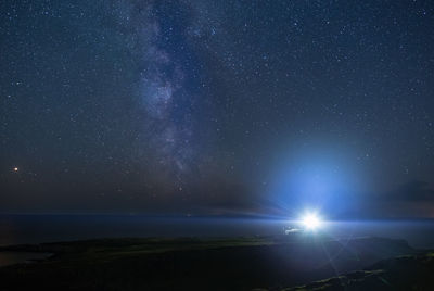 Scenic view of sea against star field at night