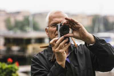 Senior man using camera during photography course