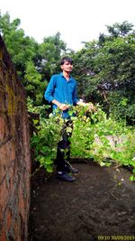 Full length of young man standing against trees