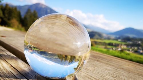 Close-up of glass on table against mountain