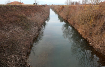 High angle view of canal amidst trees against sky