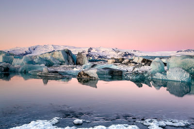 Scenic view of frozen lake against sky during sunset