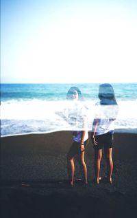 Multiple image of young woman standing on beach against clear sky