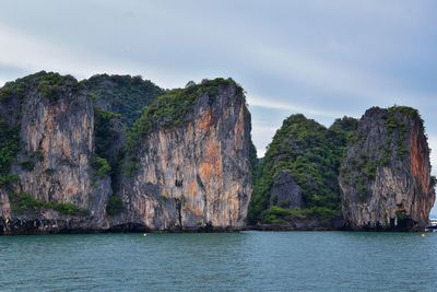 Rock formations by sea against sky