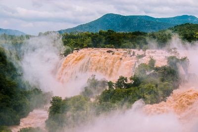 Scenic view of waterfall against sky